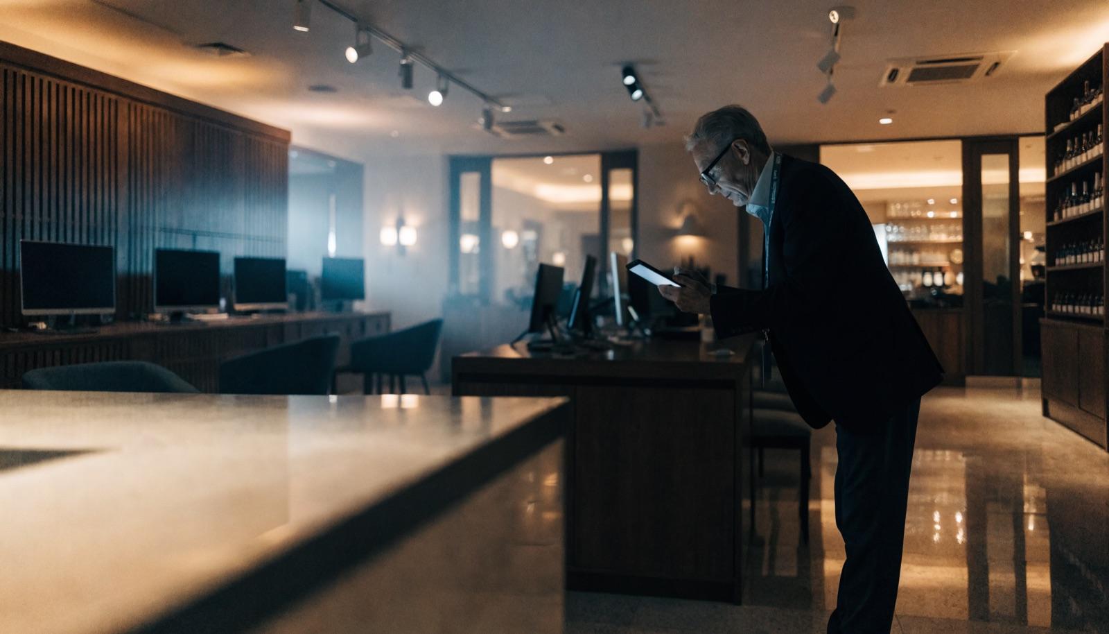 A hotel manager reviewing data on a tablet in a business center
